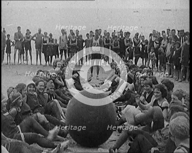 A Group of Female Civilians Exercising with a Large Ball on a Beach, 1920. Creator: British Pathe Ltd.