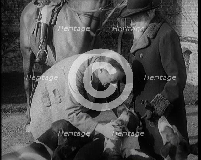 Prime Minister Stanley Baldwin Petting Dogs. Beside Him a Male Civilian Stands Next to a Horse, 1924 Creator: British Pathe Ltd.