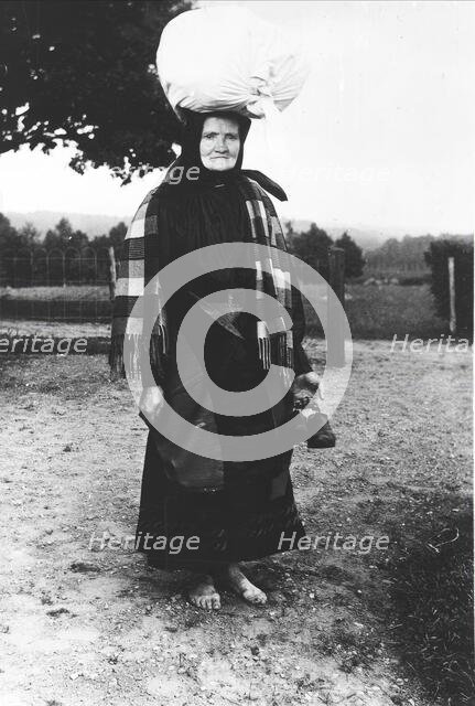 Barefoot woman carrying a sack on her head, walking to sell tissues, Mark's district,..., 1900-1910. Creator: Unknown.