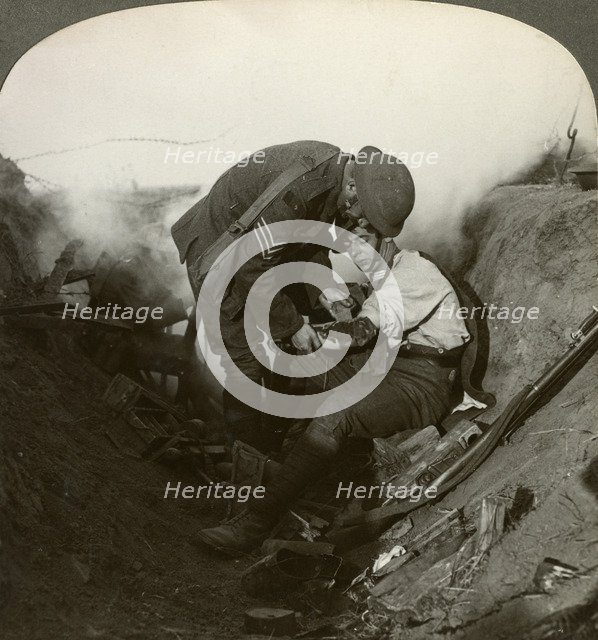 Soldier receiving first aid from a sergeant in a sap, Battle of Peronne, World War I, 1914-1918.Artist: Realistic Travels Publishers