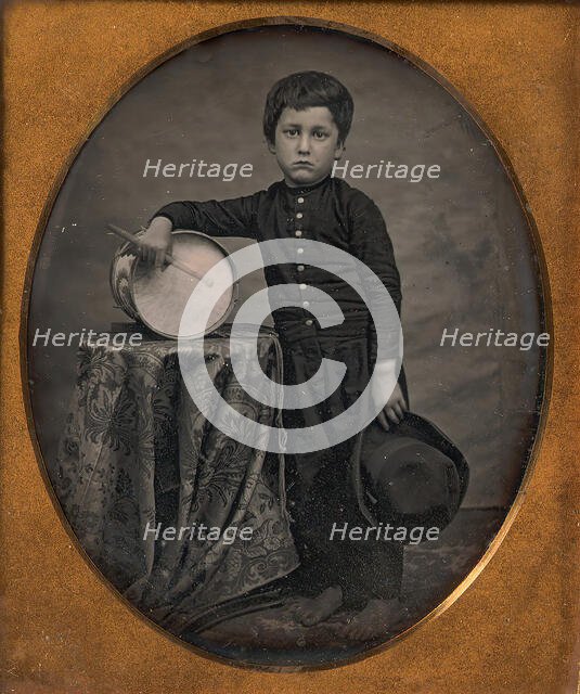 Barefoot Boy Holding Hat and Drum Stick, Leaning Forearm on Child-sized Drum on Table, 1850s. Creator: Unknown.