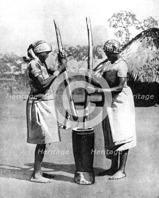Two Mashona tribeswomen pounding maize and millet, Zimbabwe, Africa, 1936.Artist: Wide World Photos