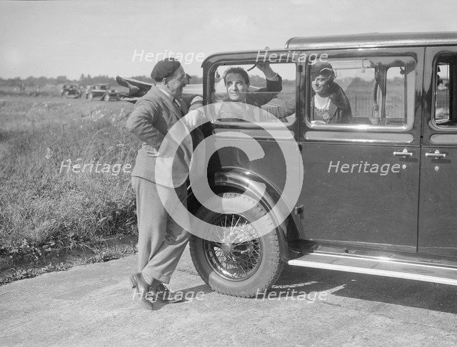 Hugh McConnell, Sammy Davis and Mrs Davis with an Austin 20/6 landaulette at Brooklands, 1931. Artist: Bill Brunell.