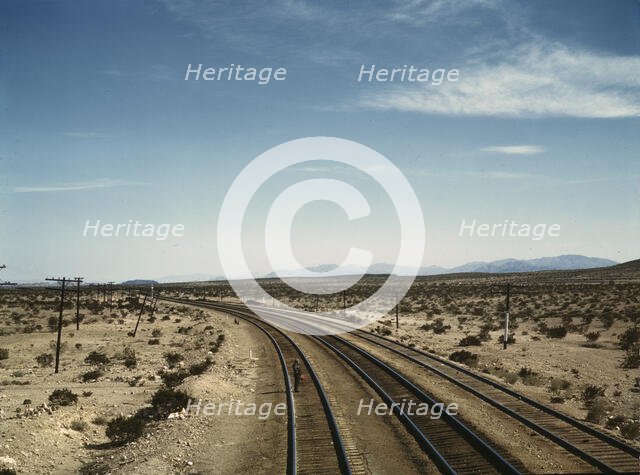 Flagman standing at a distance behind a Santa Fe R.R. west bound freight..., Bagdad, Calif., 1943. Creator: Jack Delano.