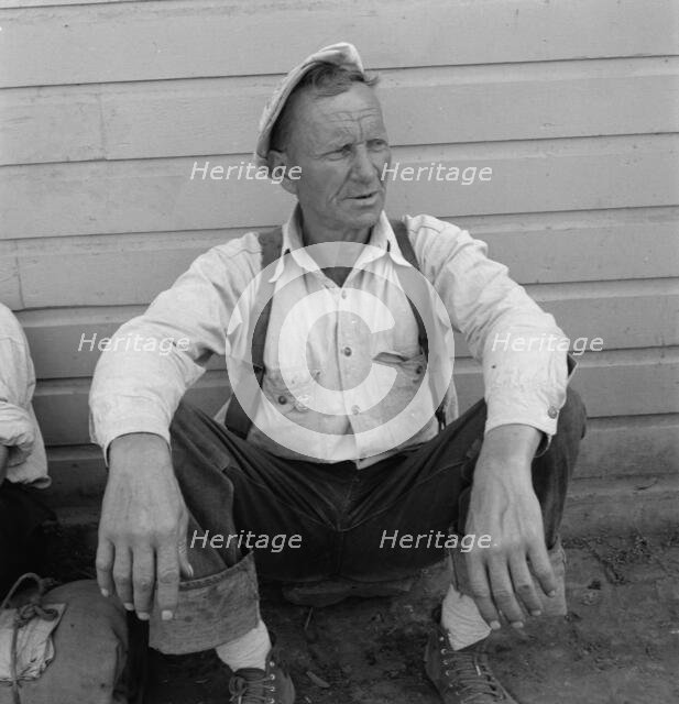 Bindle stiff, used to be logger, Side of Pastime Café, Tulelake, Siskiyou County, California, 1939. Creator: Dorothea Lange.