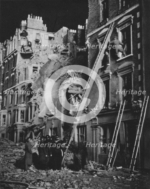 'Through the long night the rescue men at work, searching, helping to safety', 1941 (1942). Artist: Unknown.