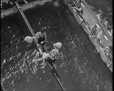 Two Male Civilians in Swim Suits Sitting on a Pole and Enjoying a Pillow Fight in Front..., 1931. Creator: British Pathe Ltd.