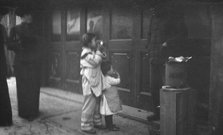 Two children standing on a sidewalk eating, Chinatown, San Francisco, between 1896 and 1906. Creator: Arnold Genthe.