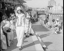 Female Civilian Wearing Smart outfit and Hat Holding a Parasol Walking Towards the Camera..., 1920. Creator: British Pathe Ltd.
