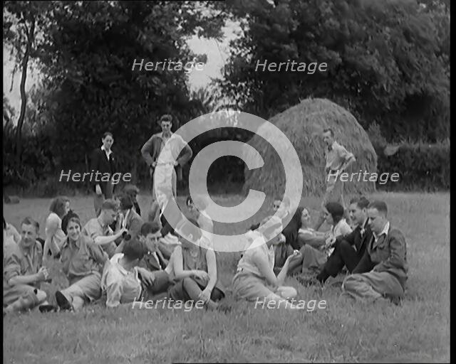A Large Group of Hikers Having Drinks in a Field Beside a Haystack, 1931. Creator: British Pathe Ltd.