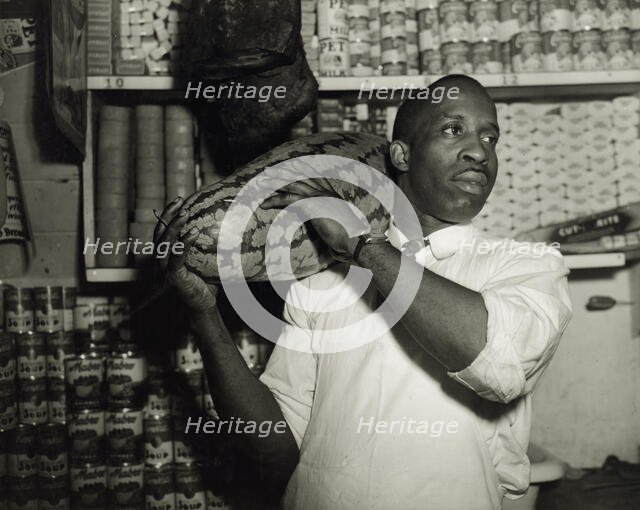 Mr. J. Benjamin, owner of the grocery store patronized by Mrs. Ella Watson..., Washington, DC, 1942. Creator: Gordon Parks.