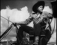 Male Civilian With a Cowboy Hat Sitting On a Coach Waiting For Passengers, 1932. Creator: British Pathe Ltd.