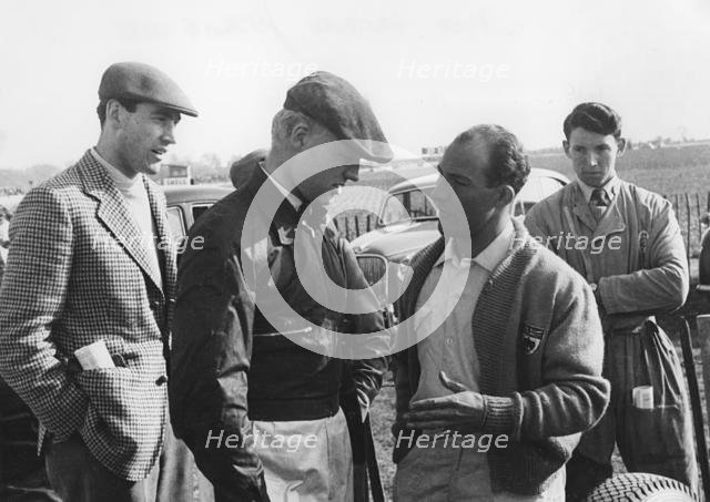 Mike Hawthorn and Stirling Moss chatting at Goodwood 1956. Creator: Unknown.