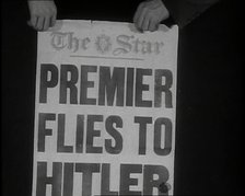 Two Hands Holding the Star Newspaper Headline 'PREMIER FLIES TO HITLER', 1938. Creator: British Pathe Ltd.