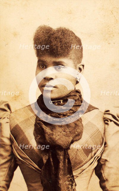Half-portrait of young woman wearing large lace scarf over plaid bodice, c1880-c1889. Creator: James O Durgan.