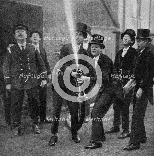 Eton's amateur firemen practising a hose drill, Berkshire, c1922. Artist: Unknown