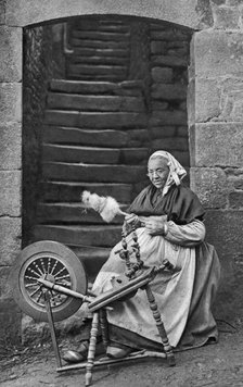 A woman at a spinning wheel, Dinan, Brittany, France, c1922. Artist: Unknown