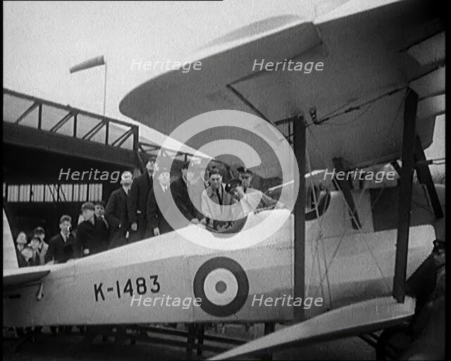 An RAF Officer Showing a Group of Male Children His Aeroplane, 1931. Creator: British Pathe Ltd.