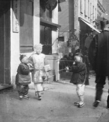 Three children standing on a sidewalk, Chinatown, San Francisco, between 1896 and 1906. Creator: Arnold Genthe.