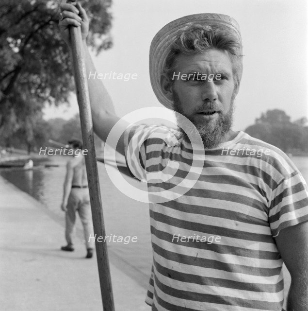 An boatman wearing a stripey T-shirt and a straw boater, Greater London, c1946-c1959. Artist: John Gay