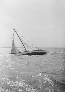The 7 Metre 'Ginerva' (K7) under sail with prize flags, 1912. Creator: Kirk & Sons of Cowes.