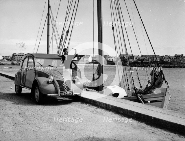 A Citroën 2CV on the quay at a harbour, c1957. Artist: Unknown