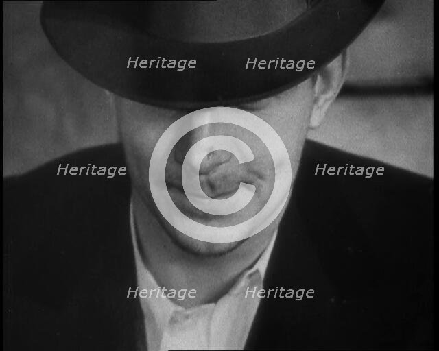 Male American Civilian Wearing a Hat Sitting at a Desk, 1930. Creator: British Pathe Ltd.