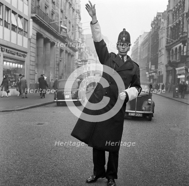 An informal portrait of a traffic policeman standing in the road, City of London, c1946-c1959. Artist: John Gay