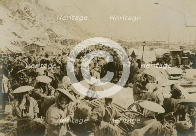 Japanese and Korean coolies removing supplies from wharf of Chemulpo, c1904. Creator: Robert Lee Dunn.