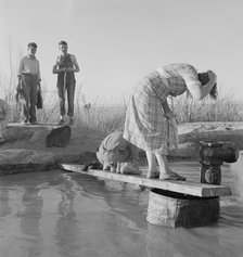Oklahoma migratory workers washing in a hot spring in the desert, Imperial Valley, California, 1937. Creator: Dorothea Lange.