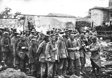 'Derriere L'ennemi refoule; Nos territoriaux distribuent du pain a des prisonniers...1915 (1924). Creator: Unknown.