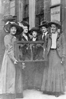 Five suffragettes holding a broken window in its frame, 1912. Artist: Unknown