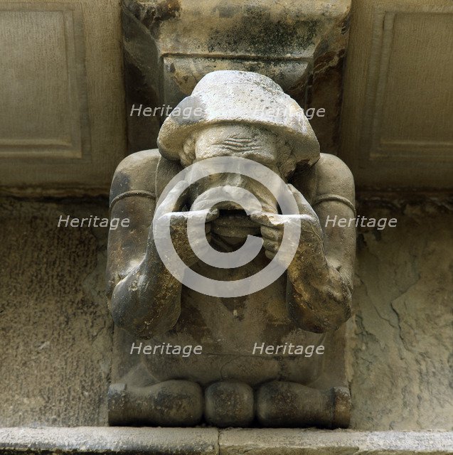Façade of the Paeria of Cervera, anthropomorphic corbel of a personage sick of the teeth showing …