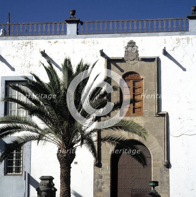 Detail of a building in Vegueta district, with a palm tree in the foreground.