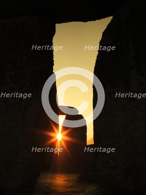 View of Stonehenge, showing the sun's rays glinting through the opening in a trilithon, 2012. Creator: James O Davies.