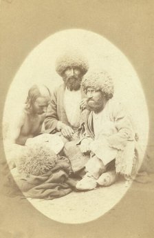 Full-length portrait of three men, seated on ground, facing front, between 1870 and 1886. Creator: Unknown.