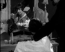 Female Civilian Having Her Hair Cut Into a 'Shingle' by a Male Civilian Hairdresser, 1920. Creator: British Pathe Ltd.