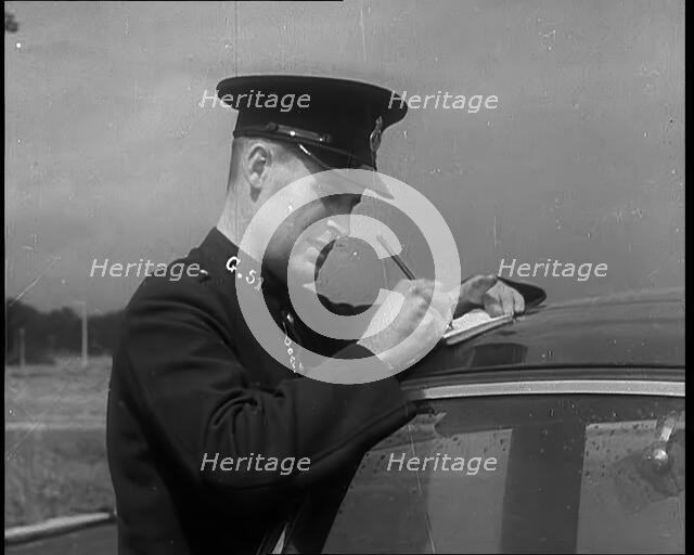 A Police Officer Writing a Ticket for a Car, 1940. Creator: British Pathe Ltd.