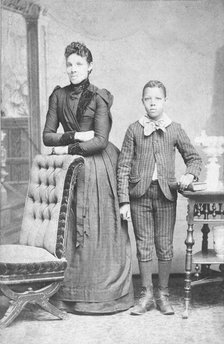 Unidentified standing figures: woman, her folded arms leaning on back of chair..., c1890. Creator: J. N. Wilson.