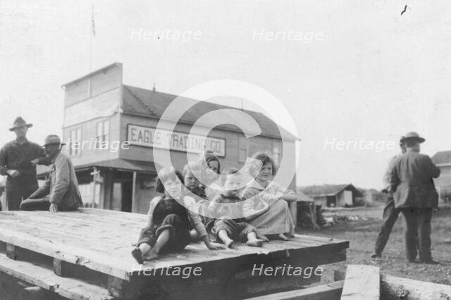 Children outside Eagle Trading Company, between c1900 and 1916. Creator: Unknown.