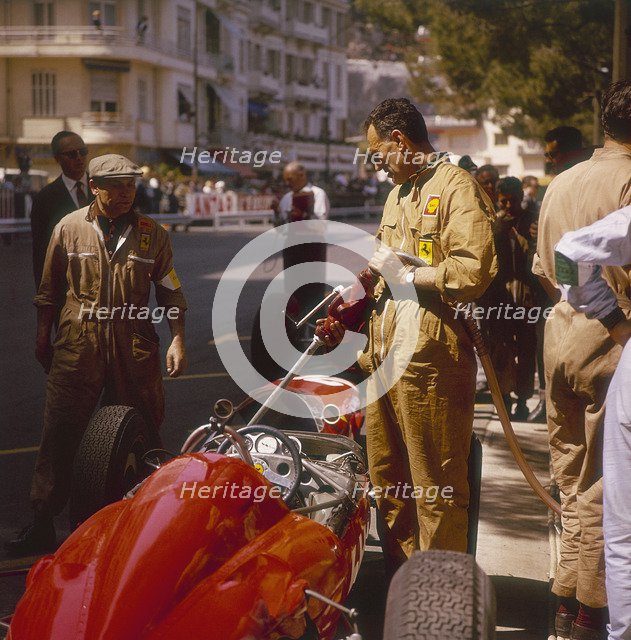 A Ferrari team member filling a car with fuel, Monaco Grand Prix, Monte Carlo, 1963. Artist: Unknown