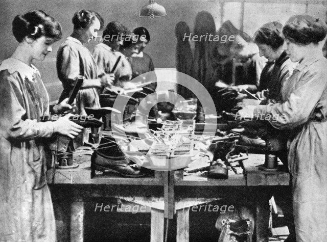 Women cobblers repairing footwear for the war effort, 1914-1918 (1936). Artist: Unknown