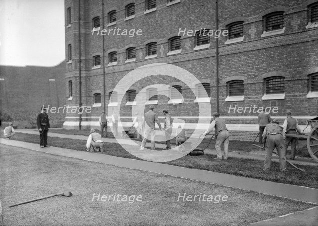 Prisoners cutting grass at Wormwood Scrubs prison, London, c1900-1950. Artist: Unknown