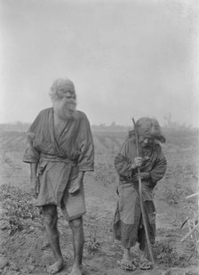 Ainu man and woman standing outside, 1908. Creator: Arnold Genthe.