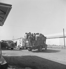 Labor contractor's truck with gang of pea pickers pulled up for gas, Westley, California, 1939. Creator: Dorothea Lange.