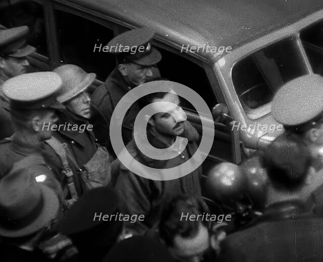 A Captured Italian Pilot Being Escorted Through a Train Station, 1940. Creator: British Pathe Ltd.