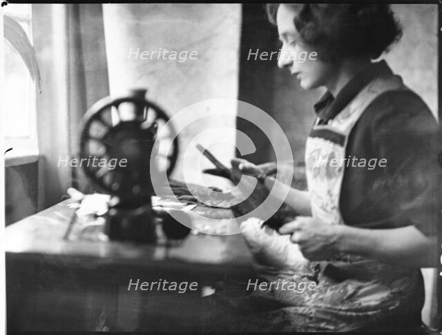 A glover or glove maker working at a sewing machine, Woodstock, Oxfordshire, 1920-40. Creator: George R Long.