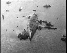 A Capsized Italian Ship at Sea Being Approached by Smaller Vessels, 1921. Creator: British Pathe Ltd.