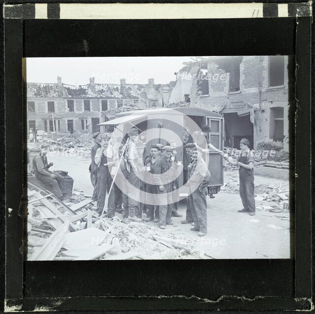 A group of men, possibly rescue workers, outside a tea van on a bomb damaged street, England, 1940-5 Creator: Norman Kingsley Harrison.