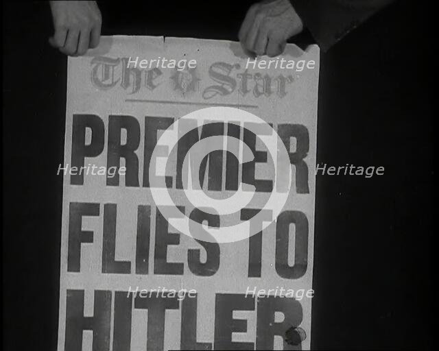 Two Hands Holding the Star Newspaper Headline 'PREMIER FLIES TO HITLER', 1938. Creator: British Pathe Ltd.